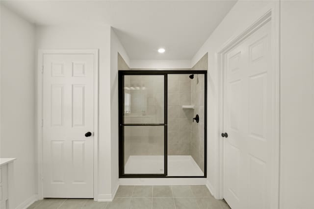 bathroom featuring vanity, tile patterned flooring, and a shower with door