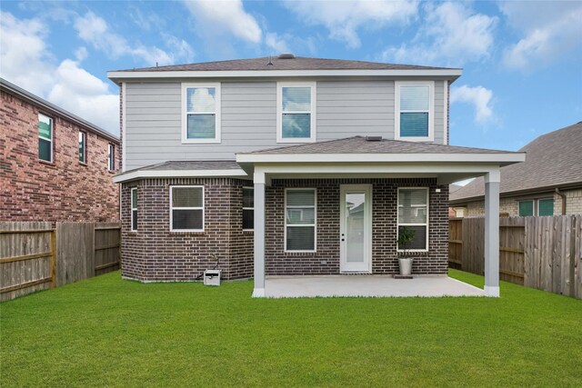 rear view of property with a lawn and a patio