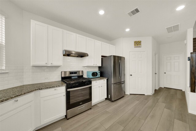 kitchen featuring appliances with stainless steel finishes, light hardwood / wood-style floors, stone counters, and white cabinets