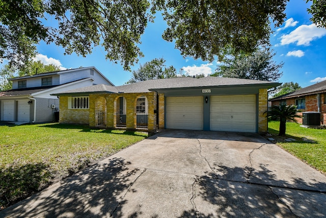 view of front of home with a front yard, central AC unit, and a garage