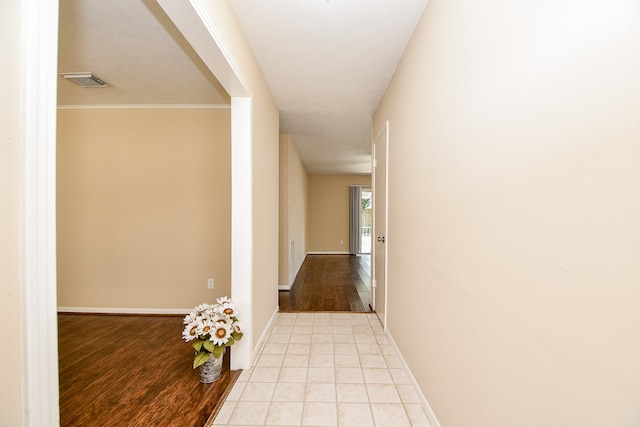 hall with ornamental molding and light hardwood / wood-style flooring