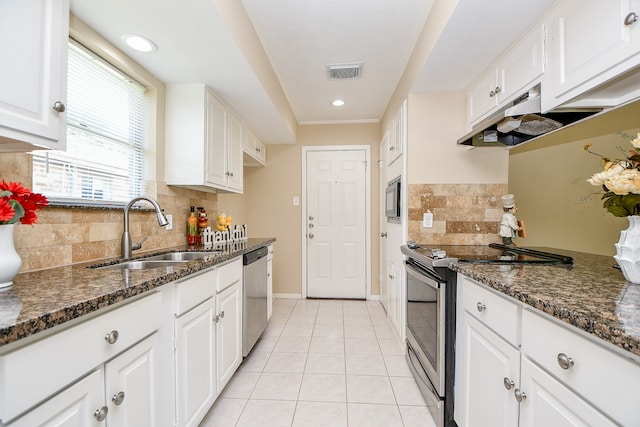 kitchen featuring dark stone countertops, appliances with stainless steel finishes, sink, and white cabinets