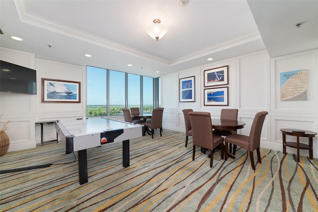 recreation room with light carpet, a tray ceiling, and crown molding