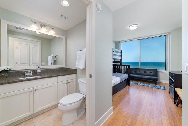 bathroom featuring vanity, hardwood / wood-style floors, and toilet