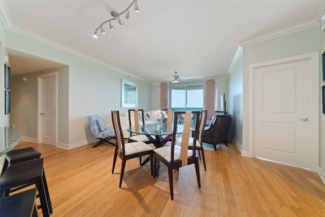 dining area with crown molding, ceiling fan, track lighting, and light hardwood / wood-style floors