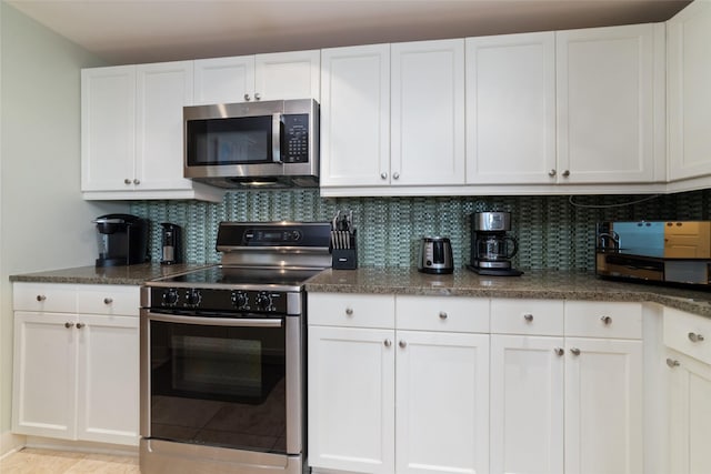 kitchen with stainless steel appliances, white cabinets, and decorative backsplash