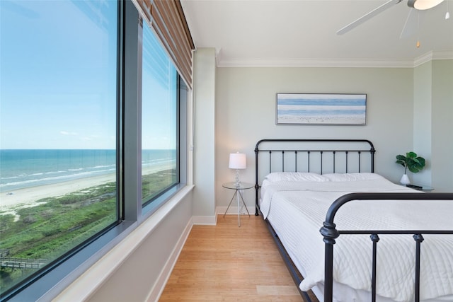 bedroom with a water view, crown molding, and multiple windows