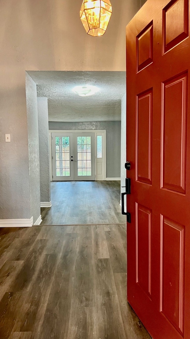 foyer featuring french doors, hardwood / wood-style floors, and a textured ceiling