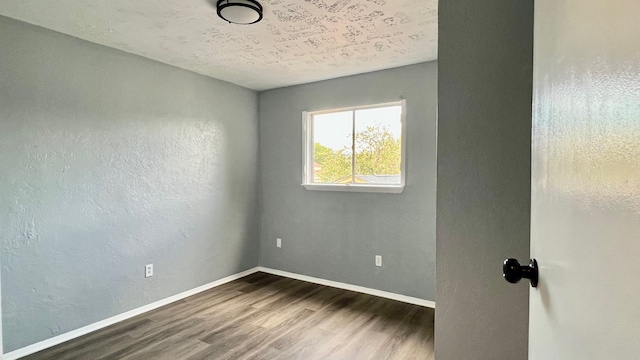 spare room with dark hardwood / wood-style floors