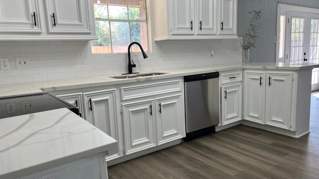 kitchen with stainless steel dishwasher, sink, white cabinets, and a wealth of natural light