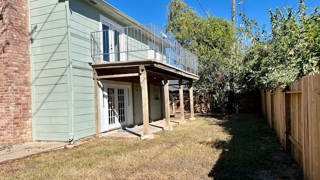 view of side of property with a patio area, french doors, and a lawn