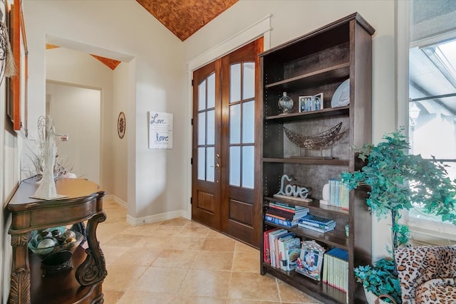 foyer featuring french doors, lofted ceiling, and a healthy amount of sunlight