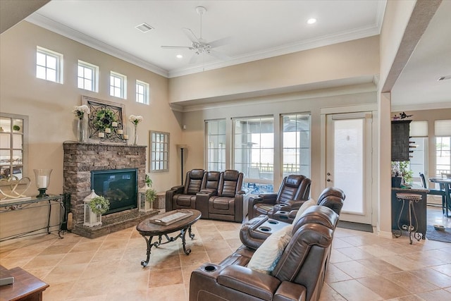 tiled living room with a fireplace, ornamental molding, ceiling fan, and plenty of natural light