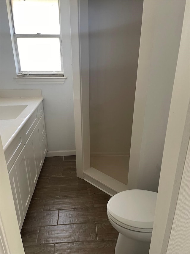 bathroom with vanity, toilet, and hardwood / wood-style flooring