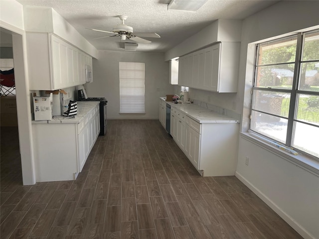 kitchen with ceiling fan, black range, dark hardwood / wood-style flooring, and white cabinetry