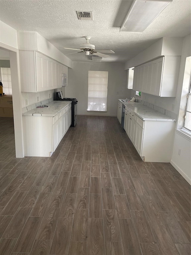 kitchen featuring stainless steel appliances, white cabinets, ceiling fan, and dark hardwood / wood-style flooring