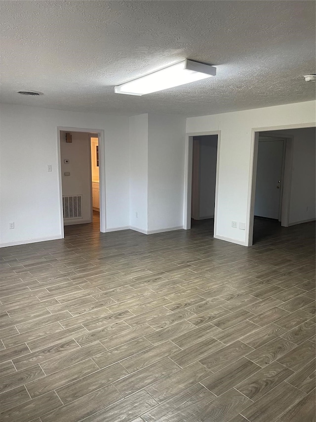 unfurnished room featuring a textured ceiling and hardwood / wood-style floors