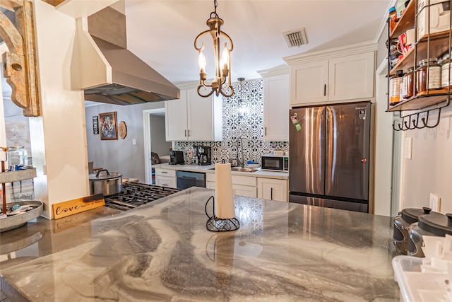 kitchen with white cabinets, black appliances, wall chimney range hood, and vaulted ceiling