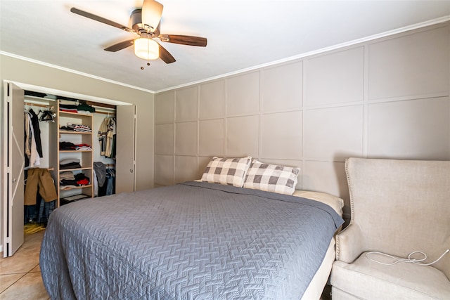 tiled bedroom with ornamental molding, a closet, and ceiling fan