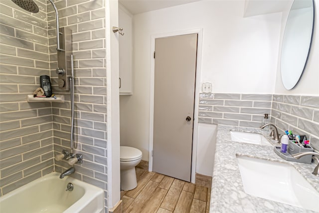 full bathroom with vanity, tiled shower / bath, and toilet