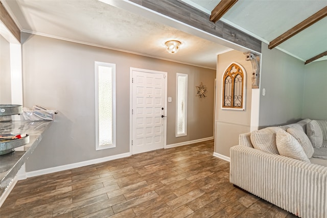 entryway with beamed ceiling, plenty of natural light, dark hardwood / wood-style flooring, and crown molding