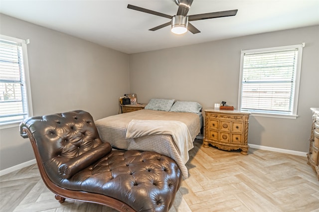 bedroom featuring ceiling fan, multiple windows, and light parquet flooring