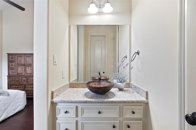 bathroom with vanity, hardwood / wood-style floors, and an inviting chandelier