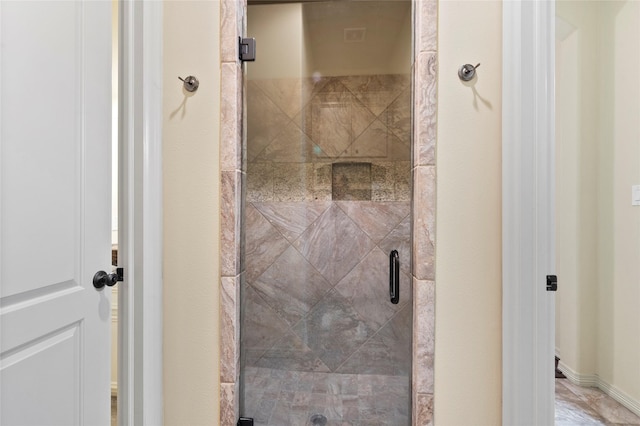 bathroom with a shower with door