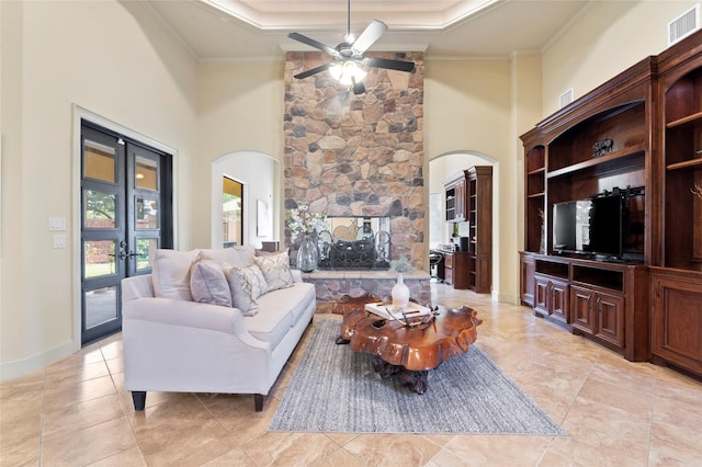 living room with crown molding, a tray ceiling, french doors, and a high ceiling