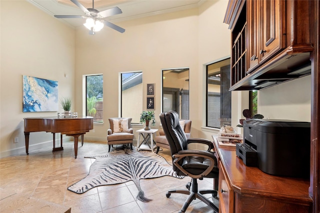 office space featuring crown molding, ceiling fan, and a towering ceiling