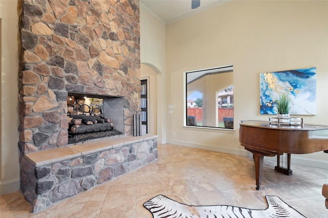 living room with crown molding, a towering ceiling, and a fireplace