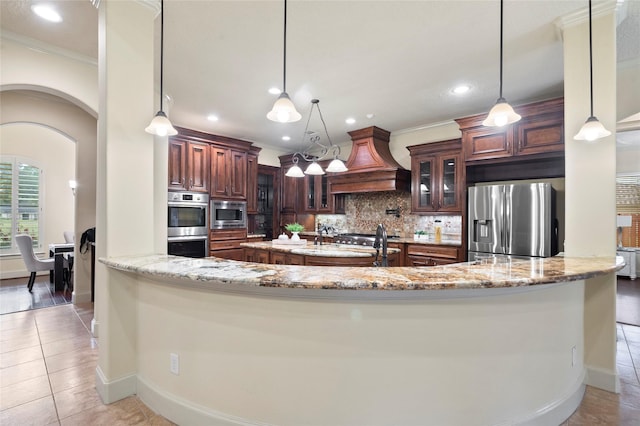 kitchen featuring decorative light fixtures, backsplash, custom exhaust hood, kitchen peninsula, and stainless steel appliances