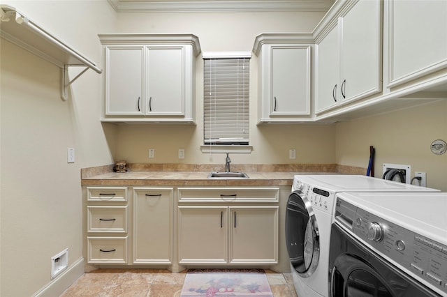 clothes washing area featuring cabinets, washer and dryer, and sink