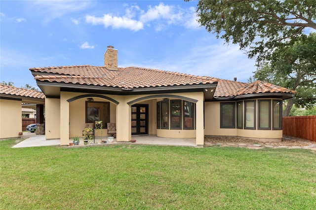 back of property with a yard and a patio area