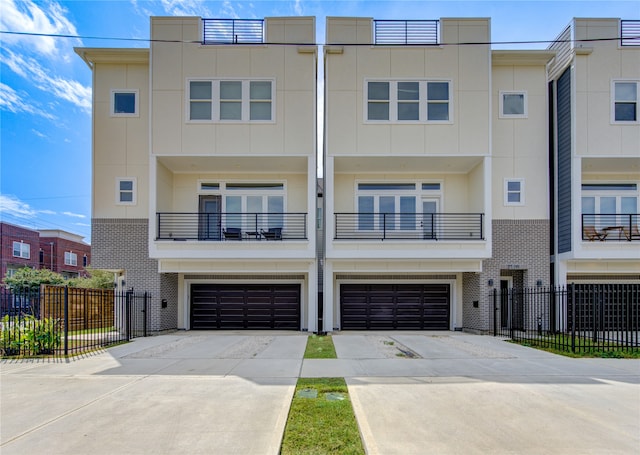 townhome / multi-family property featuring a balcony and a garage