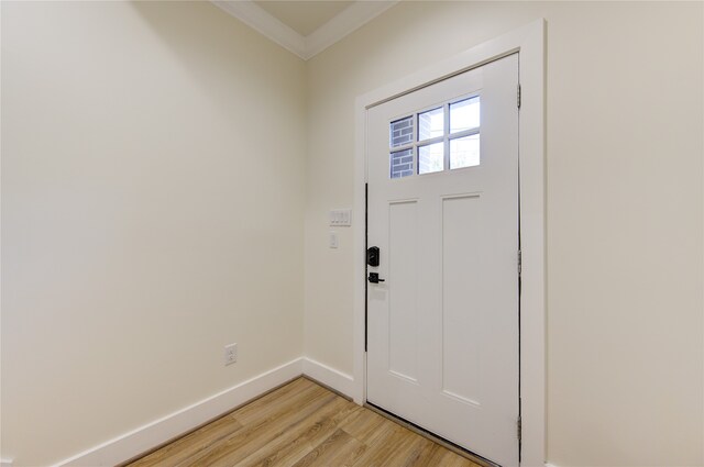 foyer with light hardwood / wood-style flooring and ornamental molding