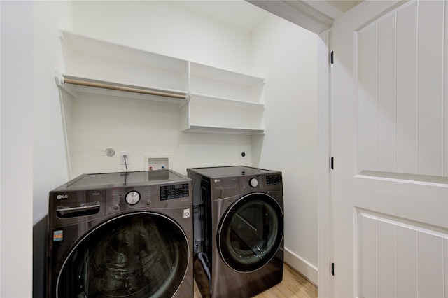 laundry area with light hardwood / wood-style floors and washer and dryer