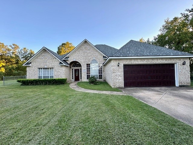 view of front of property with a garage and a front lawn