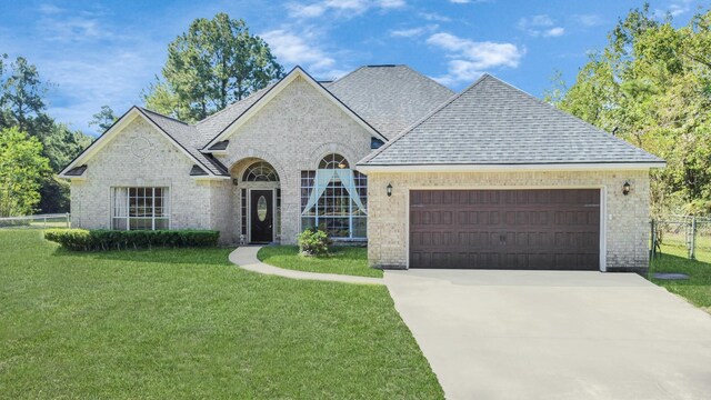 view of front of home with a garage and a front lawn