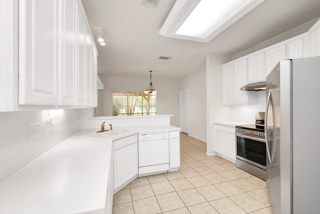 kitchen featuring kitchen peninsula, stainless steel appliances, pendant lighting, white cabinets, and sink