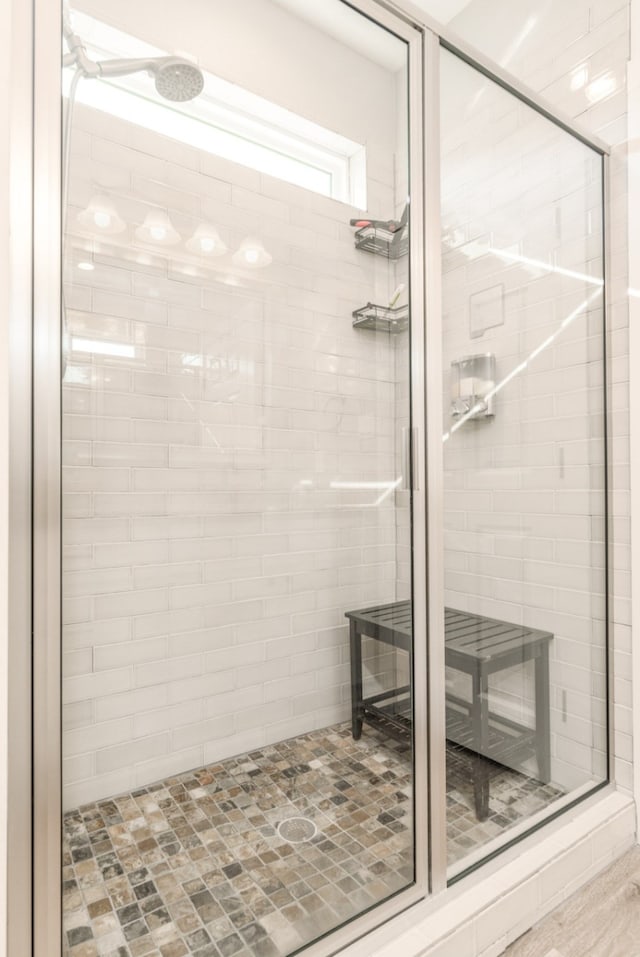 bathroom with a shower with door