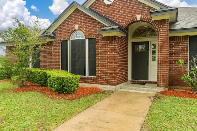 view of exterior entry featuring a yard