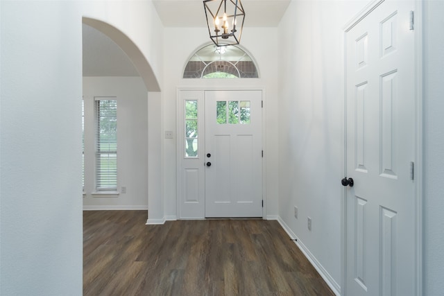 entrance foyer with dark hardwood / wood-style flooring and a notable chandelier