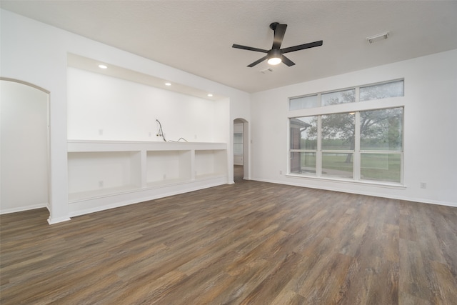 unfurnished living room with ceiling fan, dark hardwood / wood-style floors, and a textured ceiling