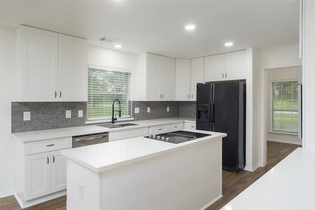 kitchen featuring black appliances, a center island, white cabinetry, and sink