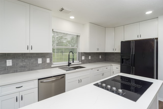 kitchen with backsplash, sink, white cabinetry, and black appliances