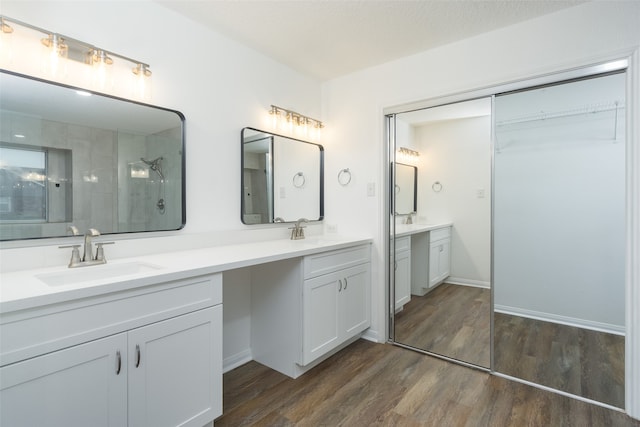 bathroom featuring hardwood / wood-style floors, walk in shower, and vanity