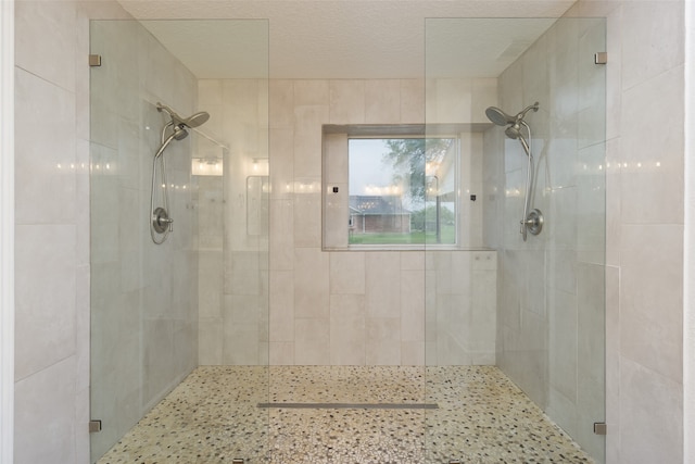 bathroom with walk in shower and a textured ceiling