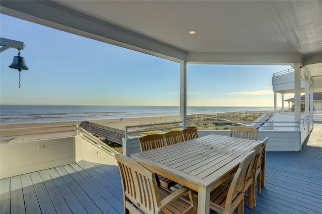 wooden deck featuring a water view and a beach view