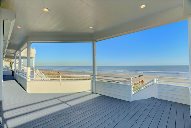 wooden deck with a water view and a view of the beach